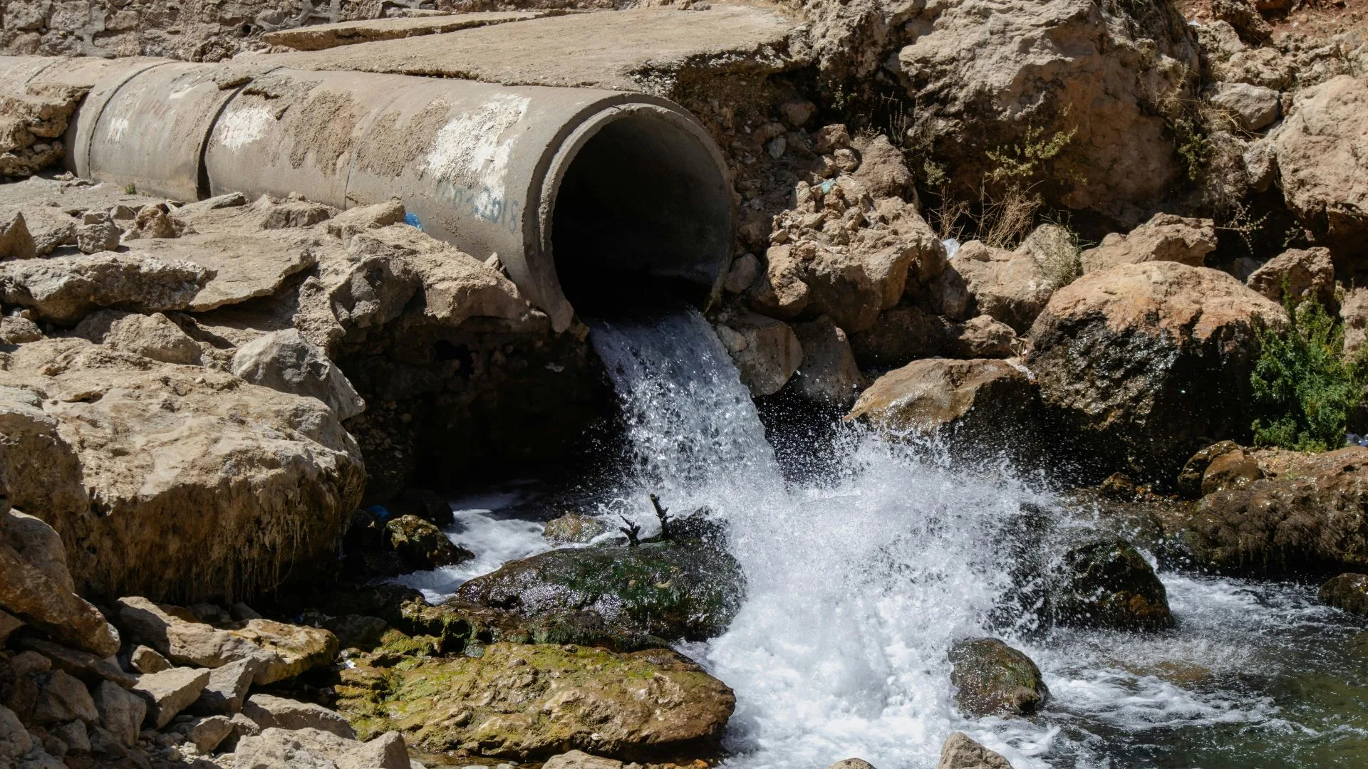 Large drainage pipe with water flowing during a stormwater system installation